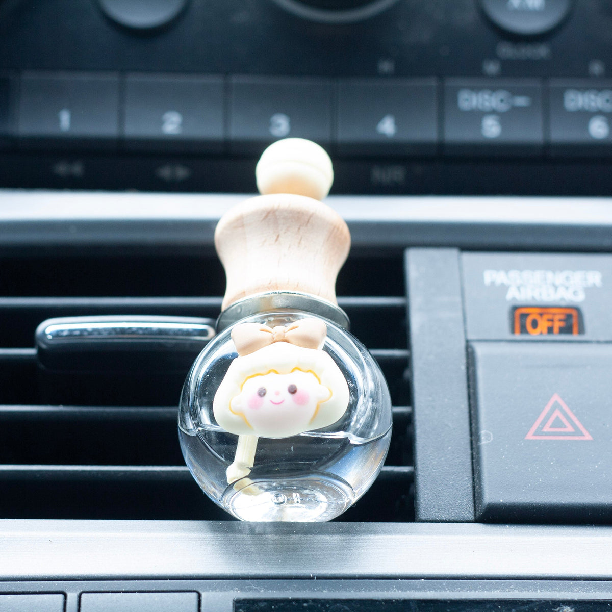 Car air freshener with a cartoon character attached to a car's air vent.